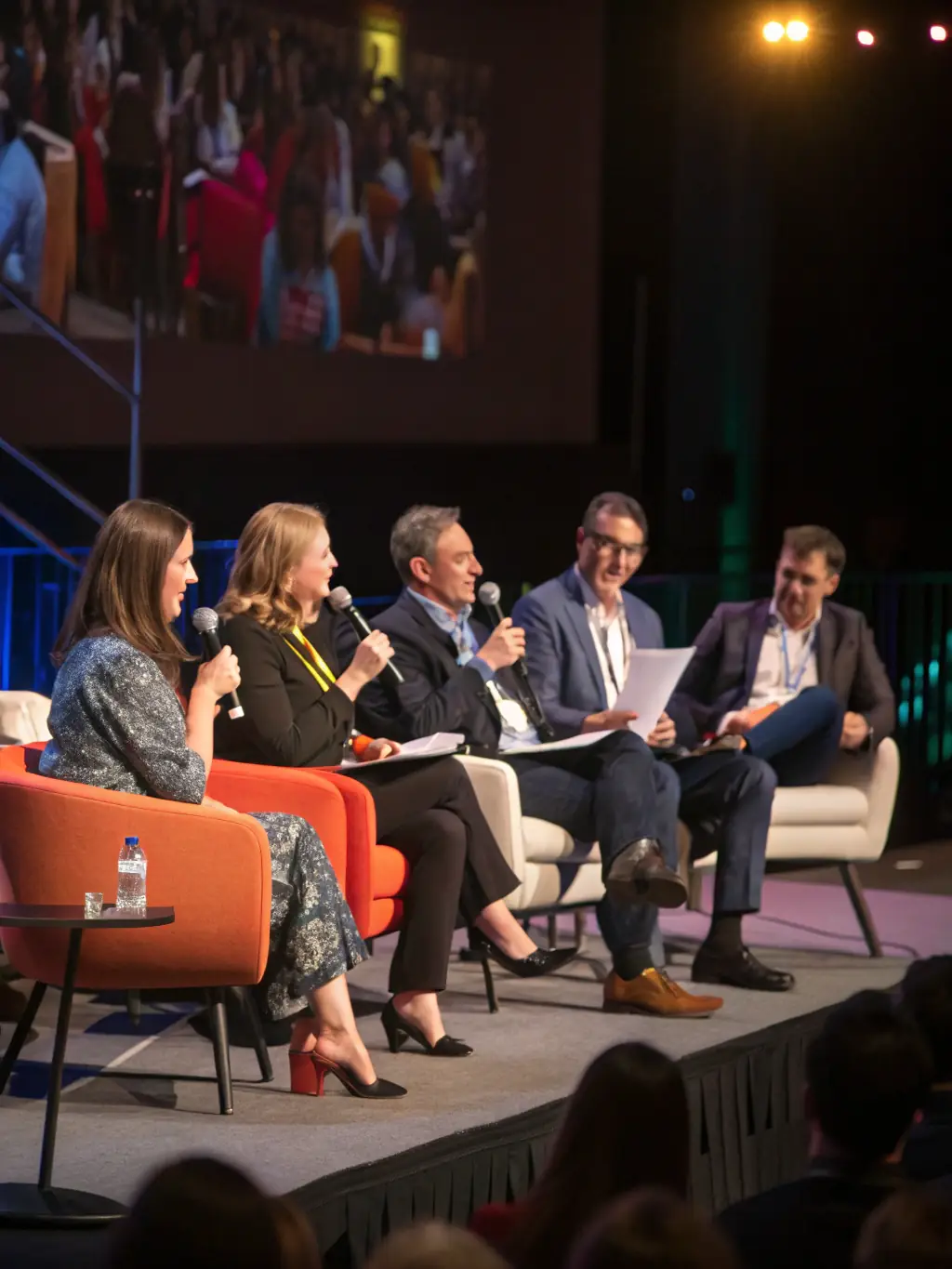 A photo of a panel discussion featuring industry leaders at the Monoclestack event, with moderators and panelists engaging in a dynamic conversation on stage.